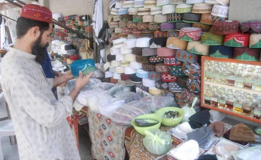 لاہور: شہری مال روڈ پر مسجد شہداء کے باہر ٹوپی خریدنے کے ..