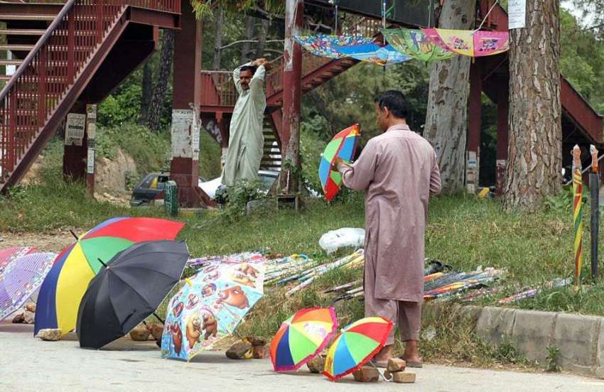 اسلام آباد: وفاقی دارالحکومت میں ایک محنت کش روڈ کنارے چھتریوں ..