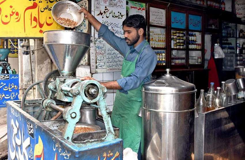 لاہور: دکاندار فروخت کے لیے باداموں کا تیل نکال رہا ہے۔