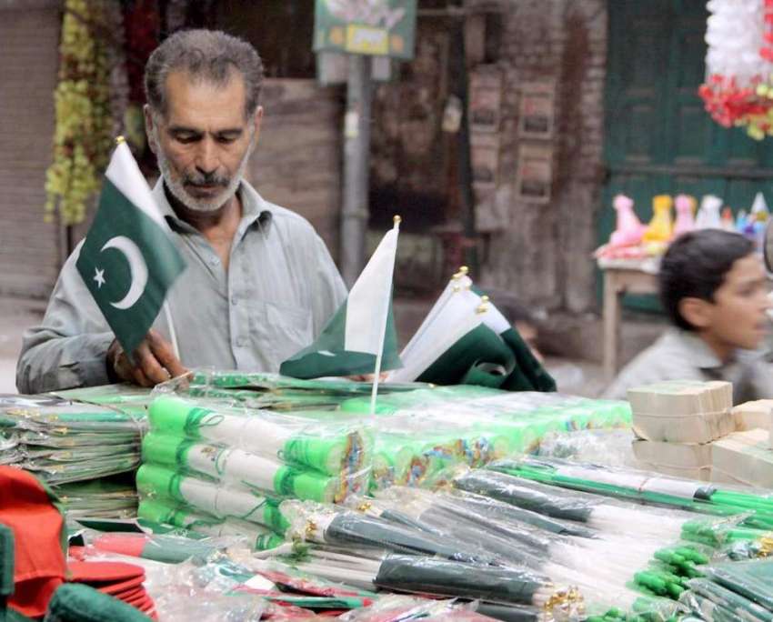 لاہور: اردوبازار میں ایک شخص جشن آزاد کے حوالے سے اشیاء کا ..