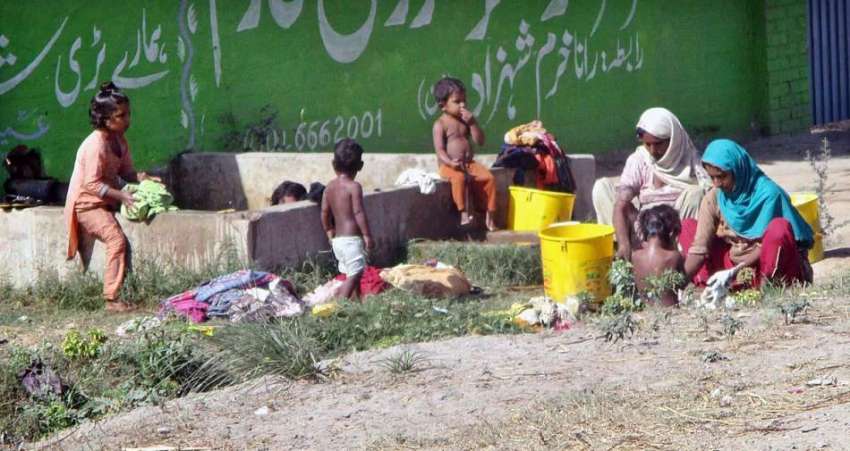 فیصل آبادء خانہ بدوش خواتین کپڑے دھو رہی ہیں۔
