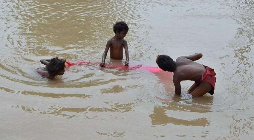 ملتان: خانہ بدوش بچے مقامی نہر سے مچھلیاں پکڑ رہے ہیں۔