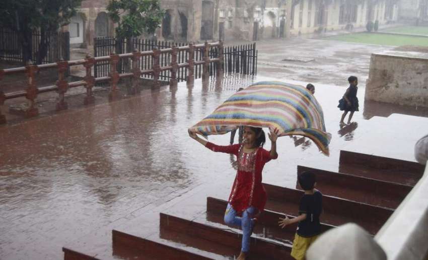 لاہور: شاہی قلعہ میں سیرو تفریح کے لیے آئی بچی بارش سے لطف ..