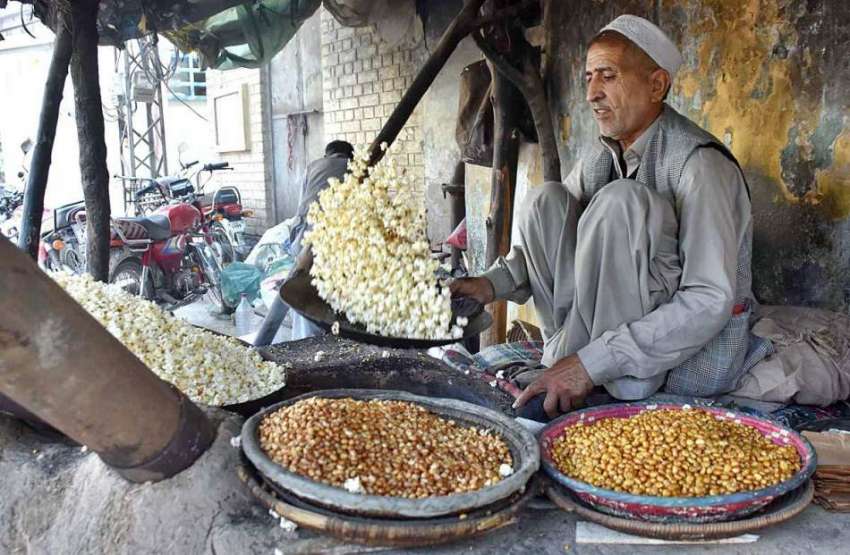پشاور: دکاندار گاہکوں کو متوجہ کرنے کے لیے بھٹی پر چنے بھون ..