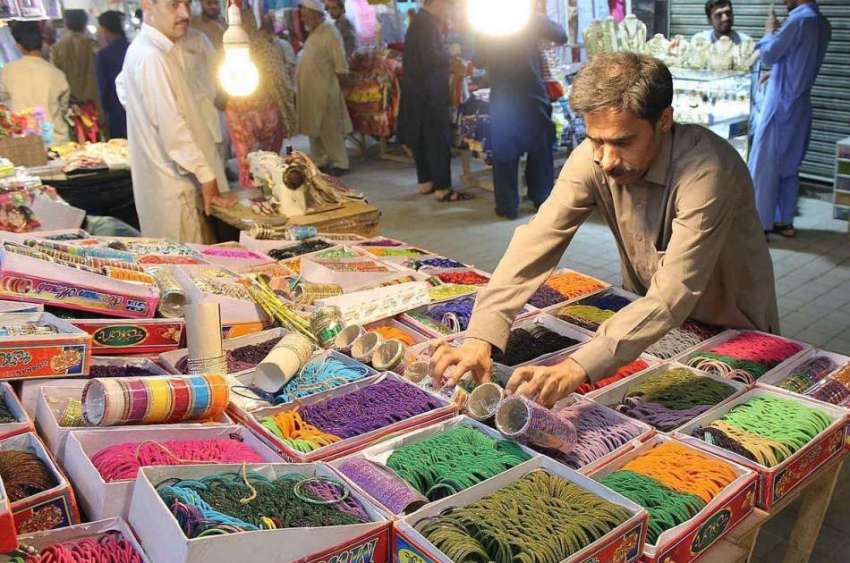 پشاور: دکاندار گاہکوں کو متوجہ کرنے کے لیے چوڑیاں سجا رہا ..