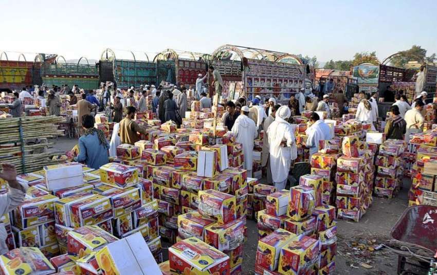 اسلام آباد: مزدور فروٹ منڈی میں ٹرک سے پھلوں کی پیٹیاں اتار ..