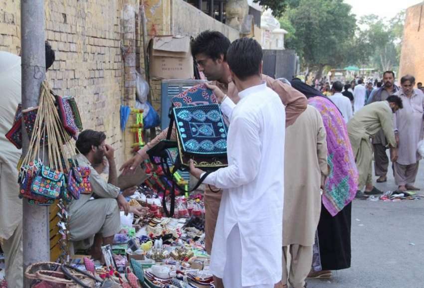 لاہور: بادشاہی مسجد کے مین گیٹ کے پاس لگے سٹالوں سے شہری ..