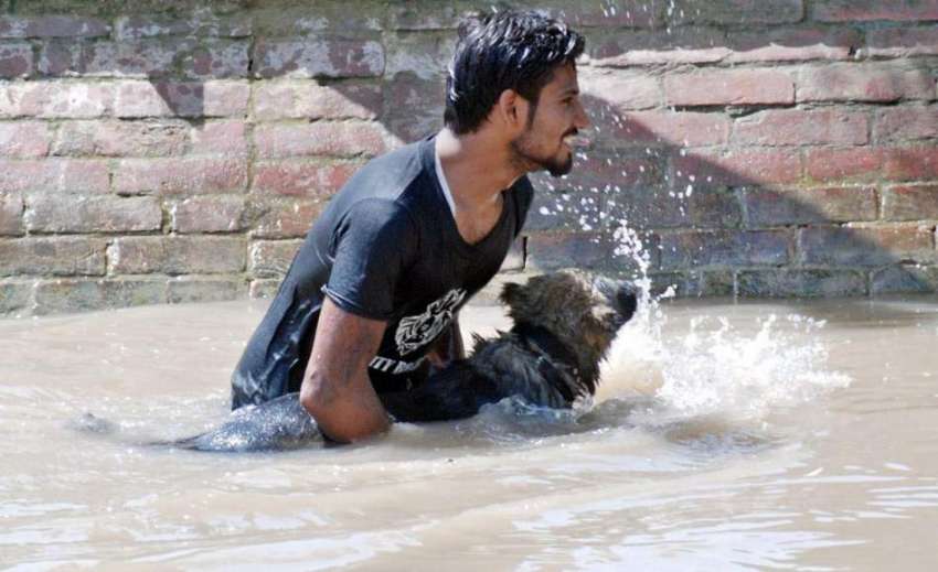 لاہور:ایک نوجوان گرمی کی شدت کم کرنے کے لیے نہر میں اپنے ..