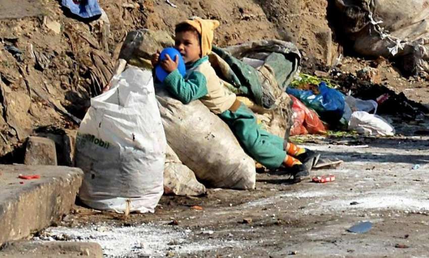 راولپنڈی: کمسن خانہ بدوش بچہ کوڑے کرکٹ کے پاس کھیل رہا ہے۔