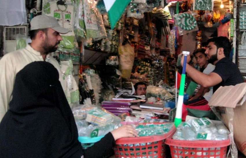راولپنڈی:14اگست کے حوالے سے شہری ایک دکان سے خریداری کر رہے ..