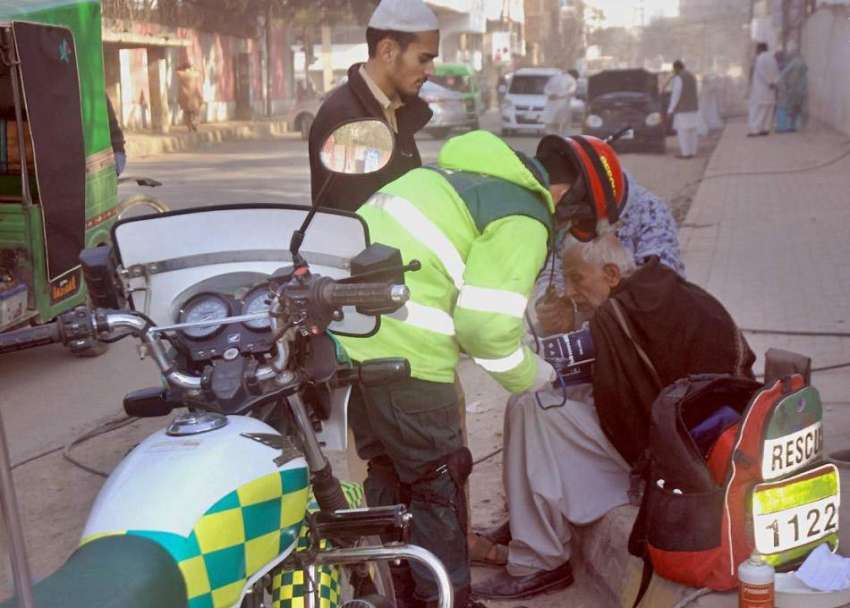 لاہور: ریسکیو اہلکار سڑک کنارے فٹ پاتھ پر ایک شہری کو طبی ..