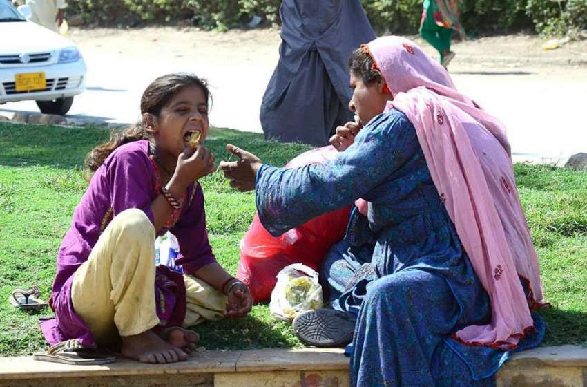 حیدر آباد: خانہ بدوش خاتون اپنی بچی کو کھانا کھلا رہی ہے۔