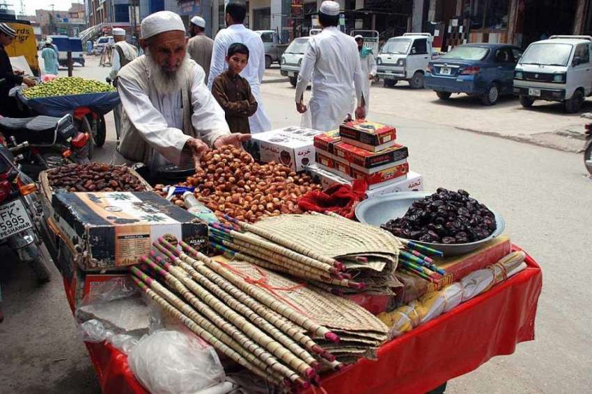 پشاور: ایک معمر محنت کش کھجوریں اور ہینڈ میڈ پنکھے فروخت ..
