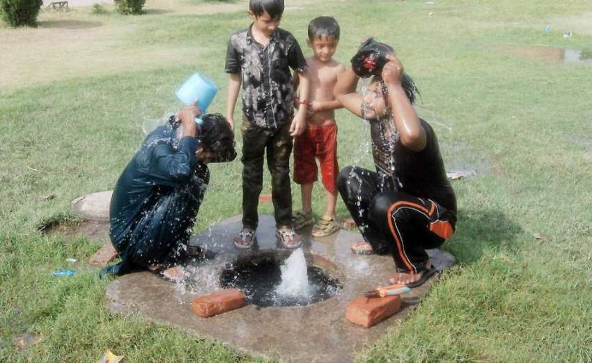 لاہور: پارک میں نوجوان گرمی کی شدت کم کرنے کے لیے نہا رہے ..
