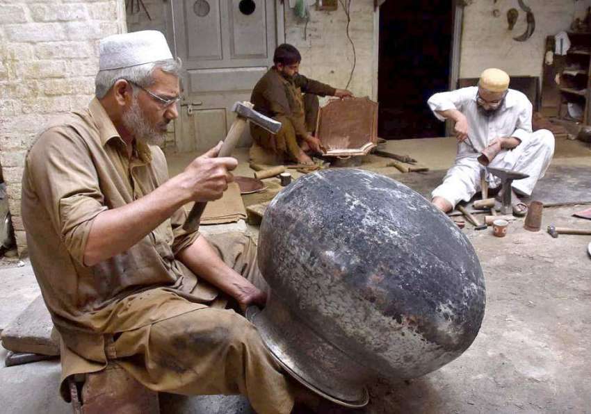 پشاور: ایک معمر محنت کش دیگ مرمت کرنے میں مصرو ف ہے۔