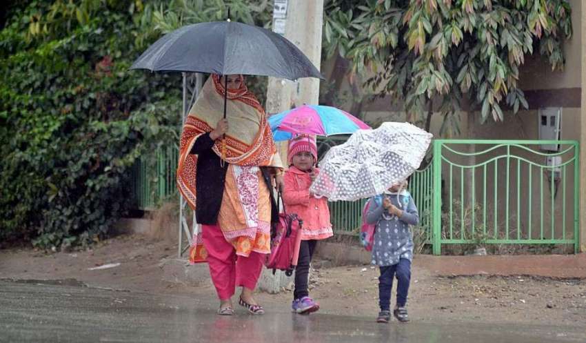 راولپنڈی: خاتون بارش سے بچنے کے لیے چھتری تانے جا رہی ہے۔