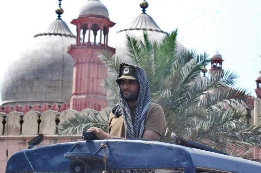 لاہور: ایک پولیس اہلکار شدید گرمی میں بادشاہی مسجد کے باہر ..