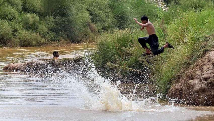 راولپنڈی: نوجوان گرمی کی شدت کم کرنے کے لیے نالہ لئی میں ..
