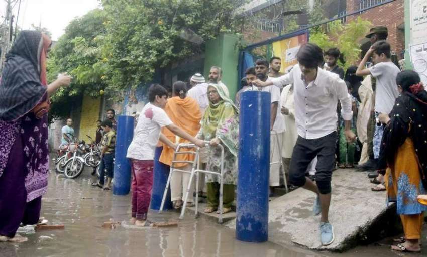 لاہور: عام انتخابات 2018  پولنگ اسٹیشن کے باہر بارش کا پانی ..