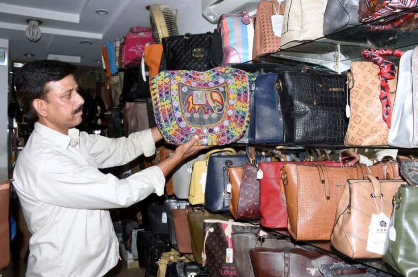 لاہور: ایک دکاندار فروخت کے لیے بیگ سجارہا ہے۔