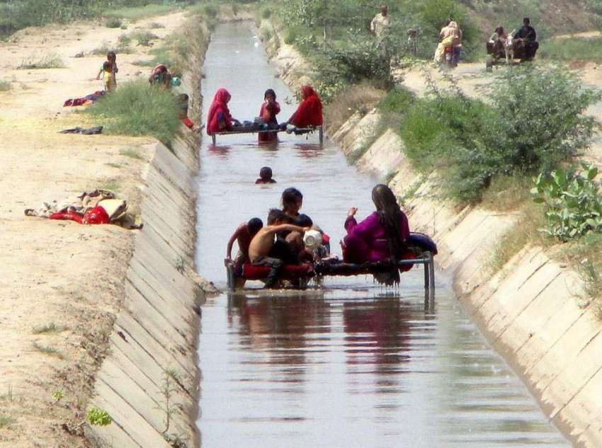 فیصل آباد: خانہ بدوش فیملی گرمی کی شدت سے بچنے کے لیے نہر ..
