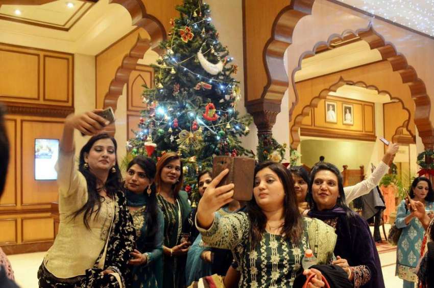 لاہور: خواتین مقامی ہوٹل میں کرسمس ٹری کے ہمراہ سیلفی بنا ..