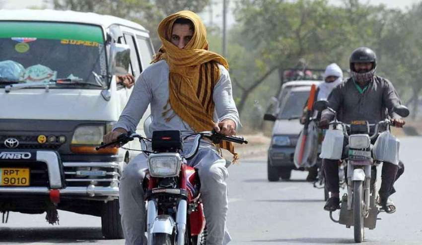 راولپنڈی: موٹر سائیکل سوار دھوپ اور گرمی کی شدت سے بچنے کے ..