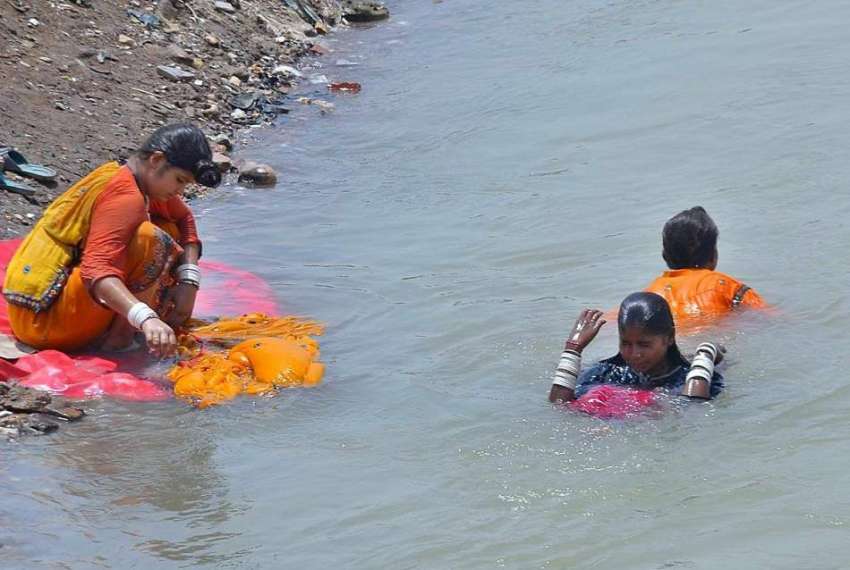 حیدر آباد: خانہ بدوش خواتین نہر کنارے بیٹھی کپڑے دھو رہی ..