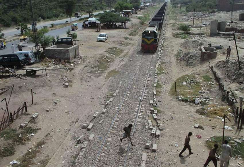 فیصل آباد: ایک شخص ریلوے ٹریک کراس کر رہا ہے جبکہ دوسری جانب ..
