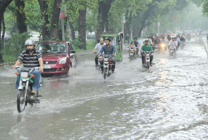 لاہور: شہری موسلا دھار بارش کے بعد مال روڈ پر جمع پانی سے ..