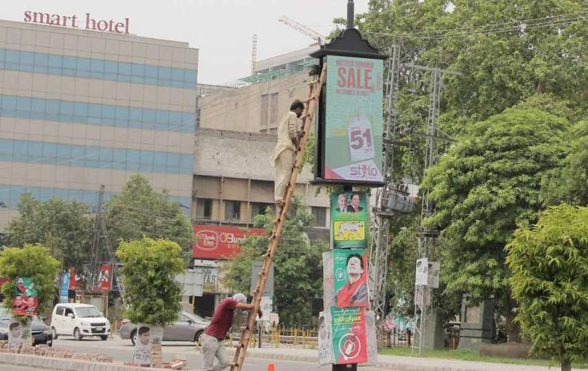 لاہور: لبرٹی چوک میں ایک کاریگر الیکٹرک اشتہاری بورڈ ٹھیک ..
