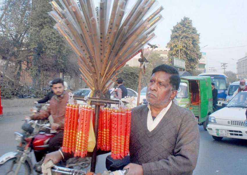 لاہور: ایک محنت کش سائیکل پر بانسریاں فروخت کر رہاہے۔