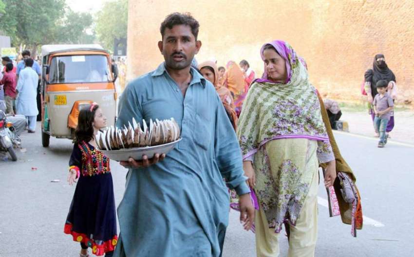 لاہور: بادشاہی مسجد کے باہر ایک شخص کچی گری فروخت کررہا ہے۔