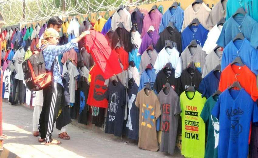 لاہور: ایک نوجوان فٹ پاتھ پر سجی دکان سے ٹی شرٹ خرید رہا ہے۔