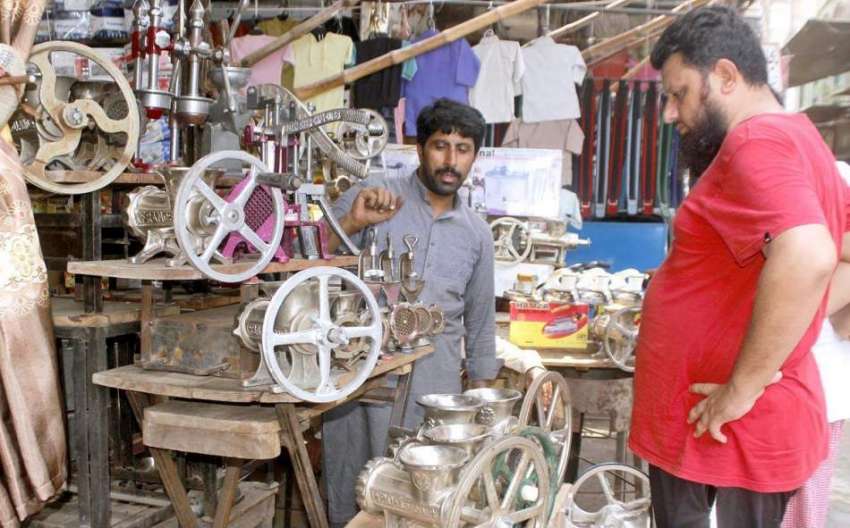 لاہور:شہری دکاندار سے قیمہ بنانے والی مشین پسند کر رہا ہے۔