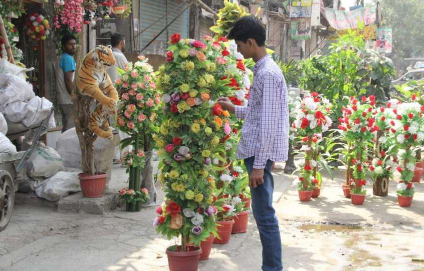 لاہور: شاہ عالم مارکیٹ میں ایک نوجوان مصنوعی پھول فروخت ..
