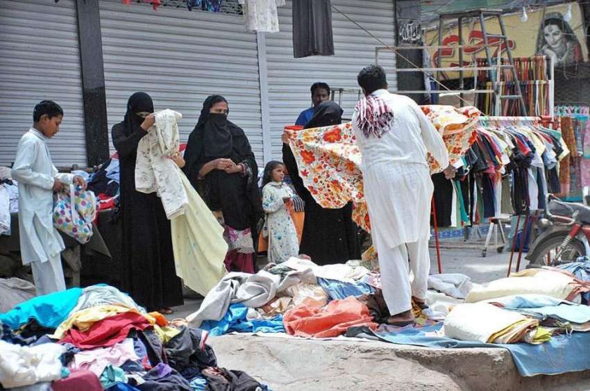 ملتان: خواتین سڑک کنارے لگے سٹال سے کپڑے پسند کر رہی ہیں۔