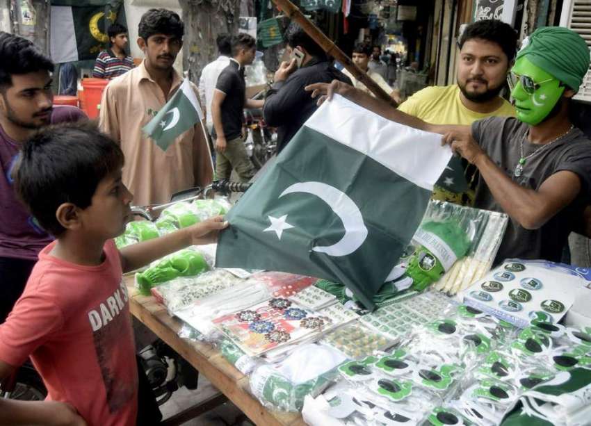 لاہور: اردو بازار میں ایک بچہ قومی پرچم خرید رہا ہے۔