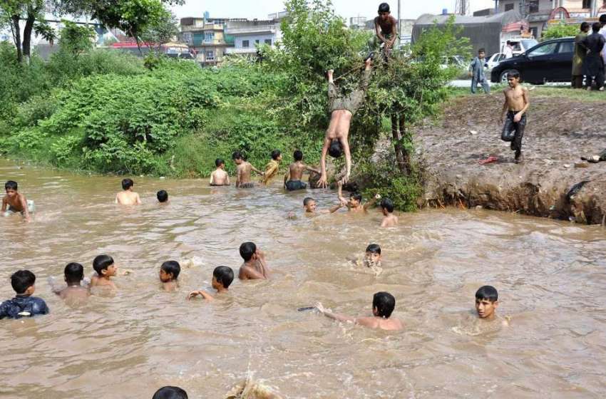 اسلام آباد: بارش کے جمع پانی میں بچے نہا رہے ہیں۔