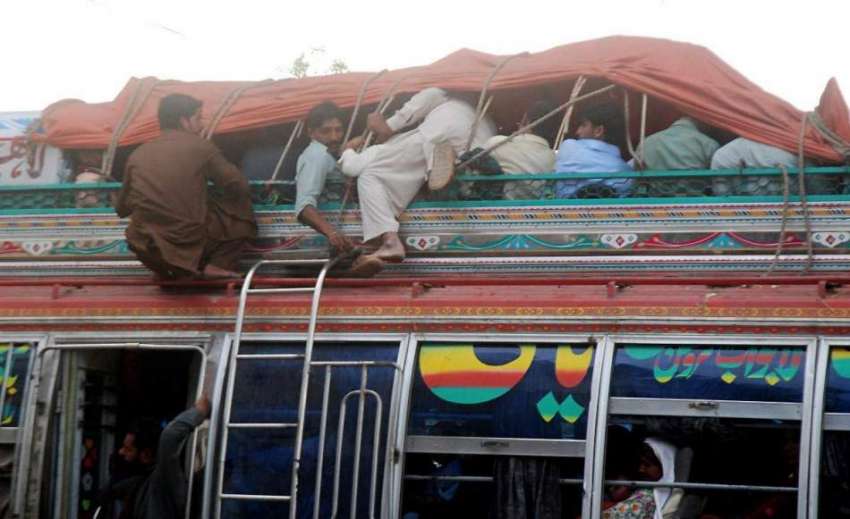 لاہور: شہری خطرناک طریقے سے بس کی چھت پر بیٹھ کر سفر کر رہے ..