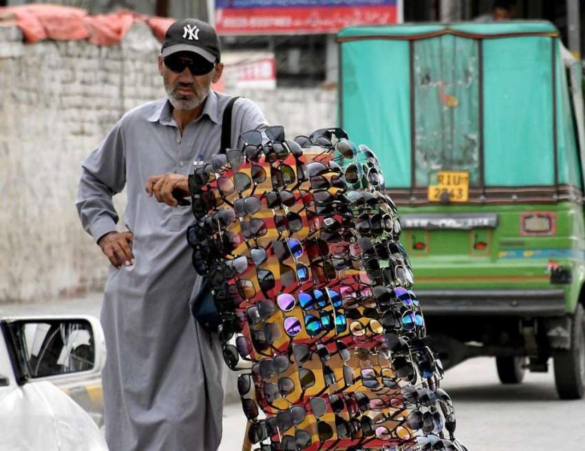 راولپنڈی: محنت کش روڈ کنارے دھوپ کے چشمے سجائے گاہکوں کے ..