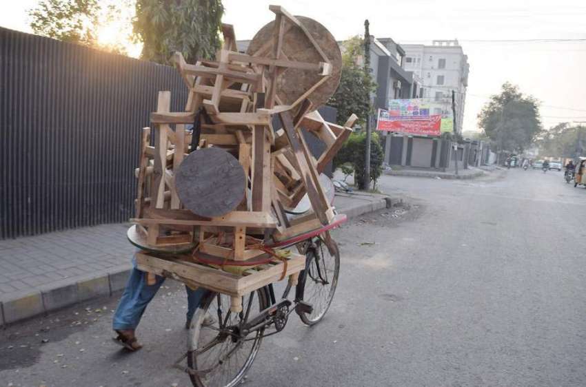 لاہور: ایک محنت کش سائیکل پر لکڑی کی اشیاء فروخت کرنے کے ..