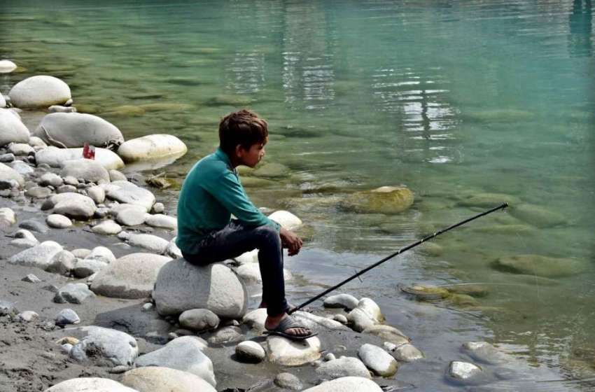 گلگت: نوجوان دریائے انڈس سے مچھلی کا شکار کررہا ہے۔