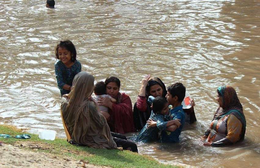 لاہور: ایک فیملی گرمی کی شدت سے بچنے کے لیے نہر میں نہا رہی ..
