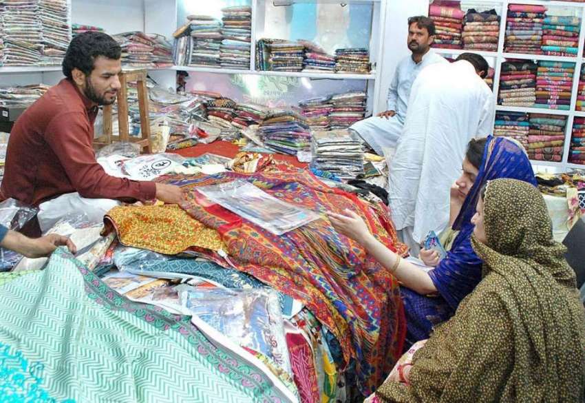 ملتان: عید کی خریداری میں مصروف خواتین کپڑے پسند کر رہی ہیں۔