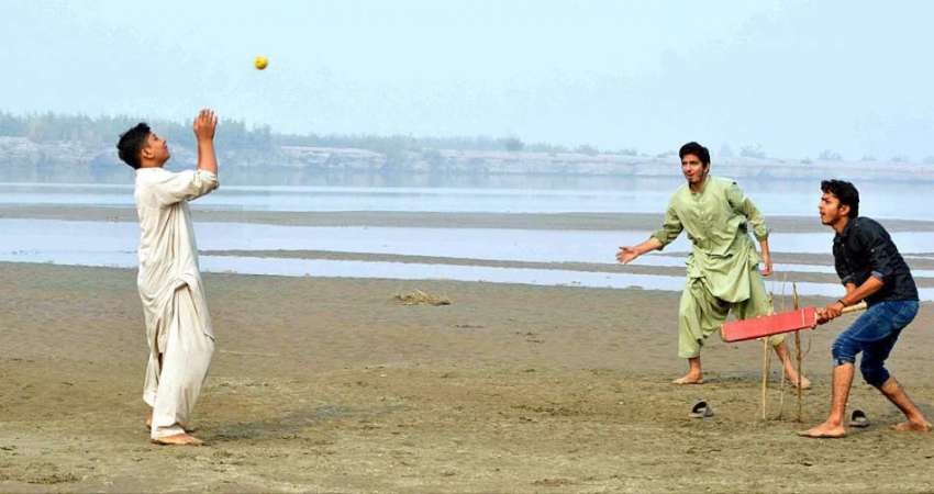 ملتان: نوجوان دریائے چناب کے قریب کرکٹ کھیل رہے ہیں۔