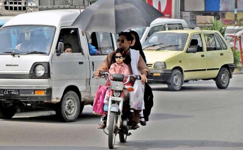 راولپنڈی: دھوپ سے بچنے کے لیے موٹر سائیکل سوار فیملی چھتری ..