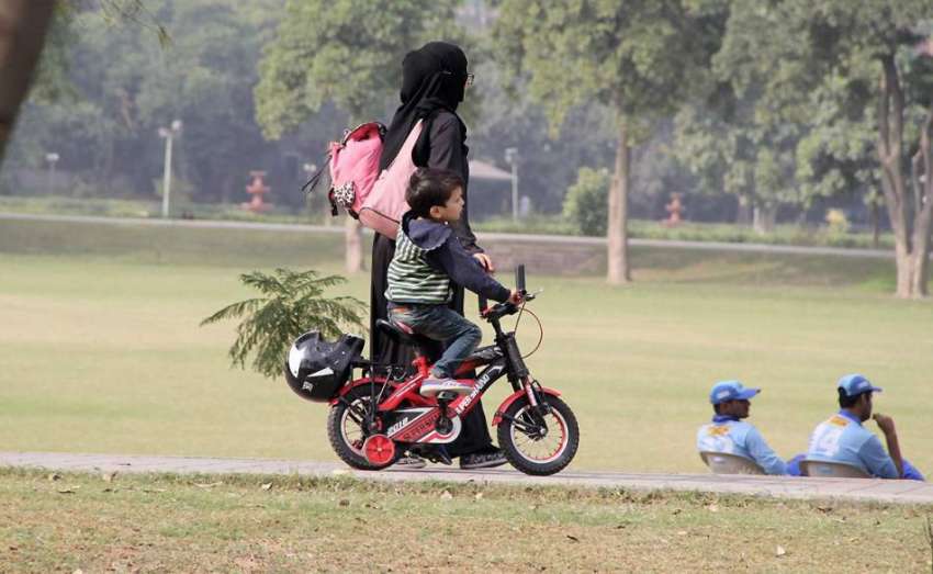 لاہور: ایک خاتون اپنے بچے کے ہمراہ جیلانی پارک کی سیر کررہی ..