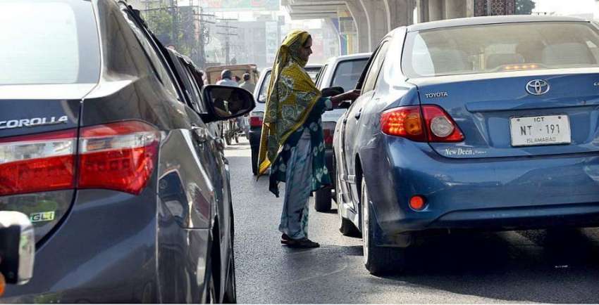راولپنڈی: ایک خاتون ٹریفک سگنل پر بھیک مانگ رہی ہے۔