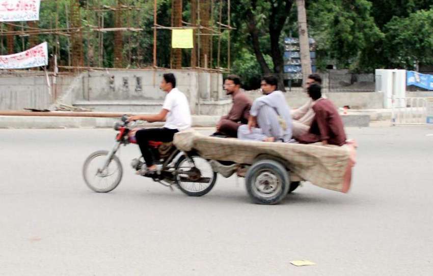 لاہور: نوجوان موٹر سائیکل کے پیچھے بندھی ریڑھی پر بیٹھ کر ..